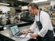 Chef reviewing food cost spreadsheet in hotel restaurant kitchen