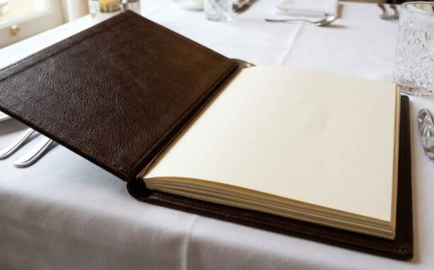 Elegant hotel restaurant a la carte menu on white tablecloth setting