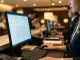 Hotel front desk staff monitoring cybersecurity alerts on a computer screen