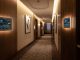 Smart thermostat screen mounted in a modern hotel hallway monitoring energy usage efficiently.