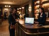 Hotel manager standing at a luxury reception desk with a modern dashboard.